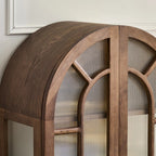 Close-up of the cabinet's curved brown top and arched glass door frames.