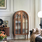 Brown arched display cabinet with patterned glass double doors and turned legs in a living room.