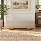Front view of the beige box-shaped bench with a narrow wood-tone base and cylindrical feet.