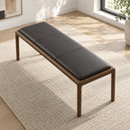 Overhead angled view of the bench's black stitched cushion and rounded brown frame.