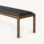 Angled detail of the black bench cushion and rounded brown frame at the right end.