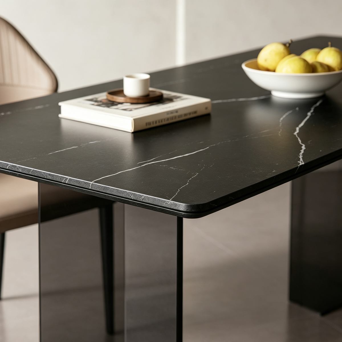 Close-up of the dining table's dark top with pale veins and a rounded corner.