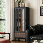 Opposite angled view of the black display cabinet beside a sofa and window.