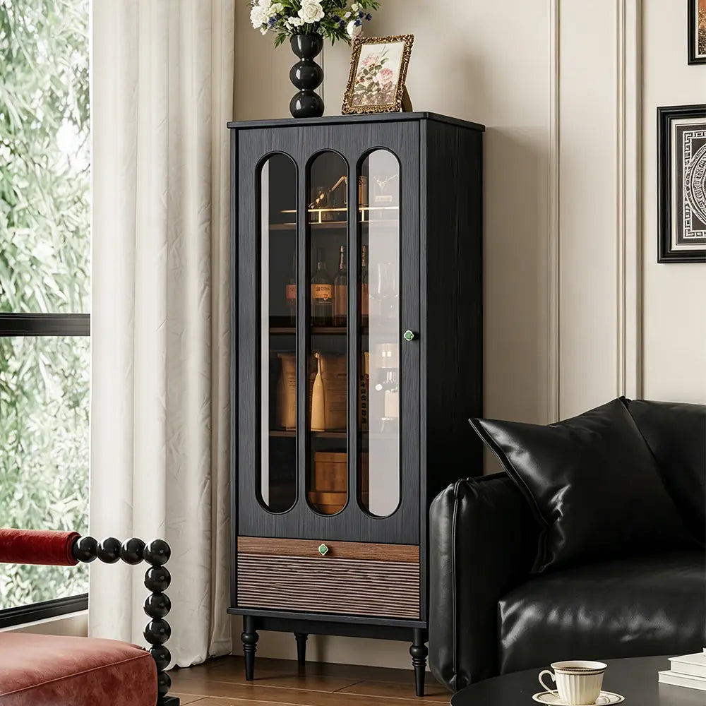 Opposite angled view of the black display cabinet beside a sofa and window.