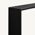 Close-up of the black console table's top edge and broad side panel.