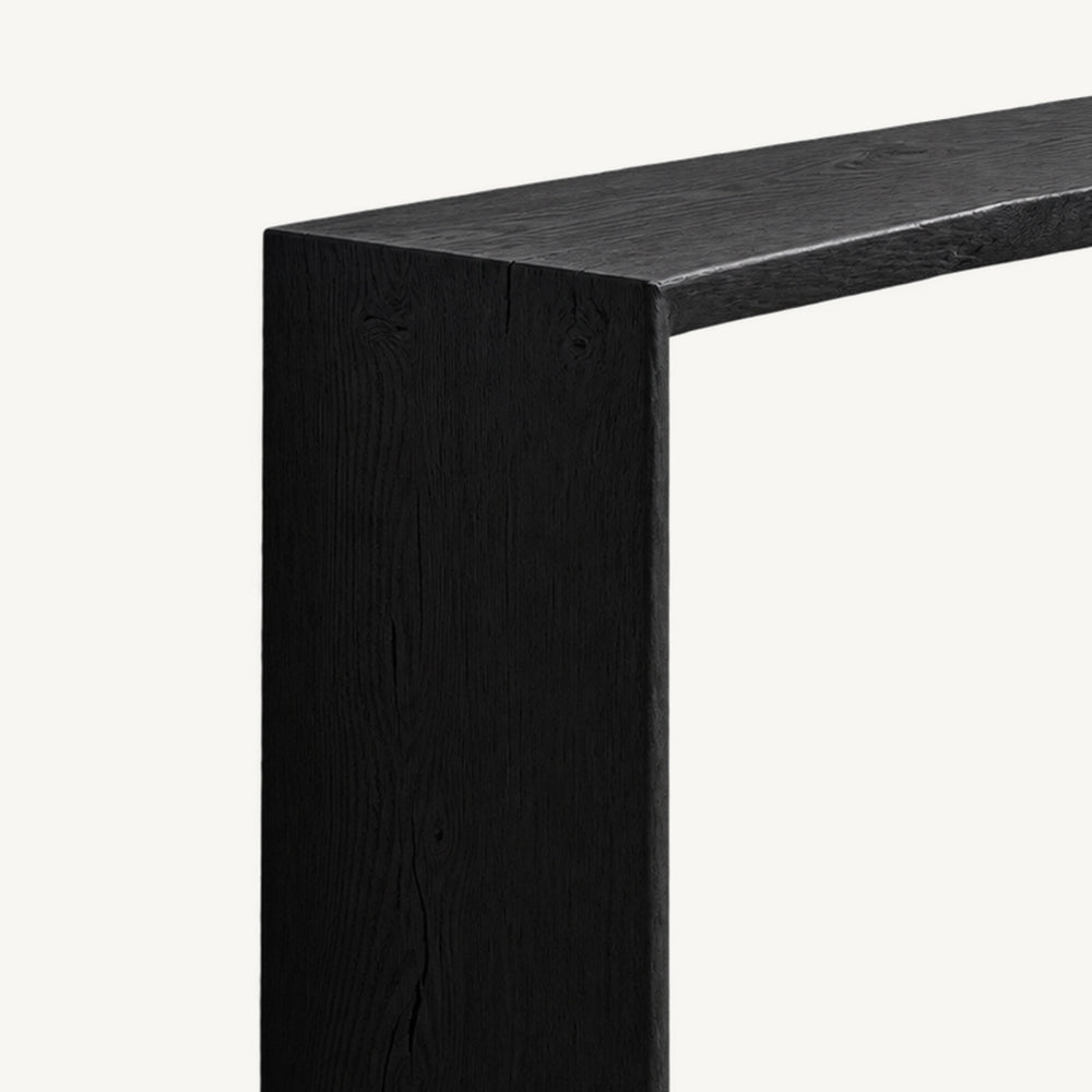Close-up of the black console table's top edge and broad side panel.