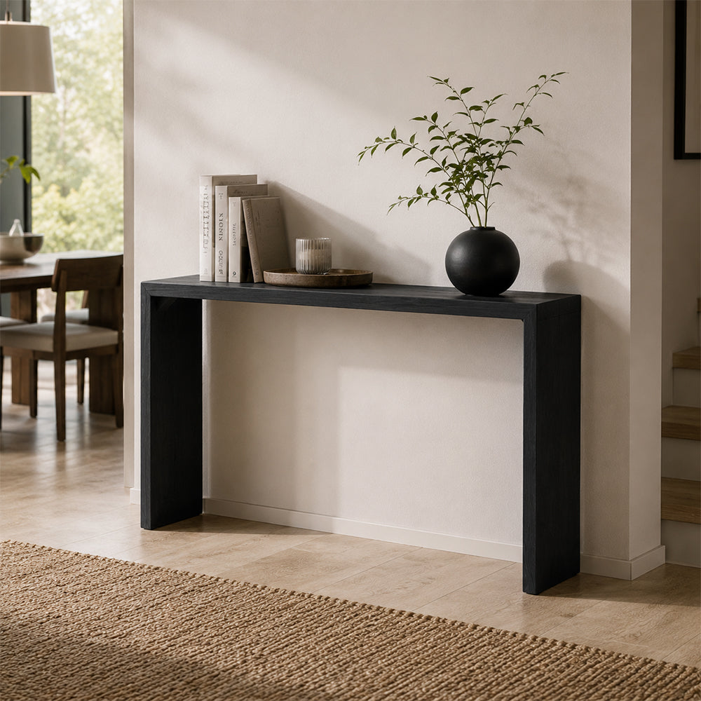 Angled view of the black slab console table against a pale entryway wall.