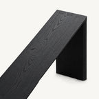 Overhead detail of the black console tabletop showing visible grain and corner joinery.