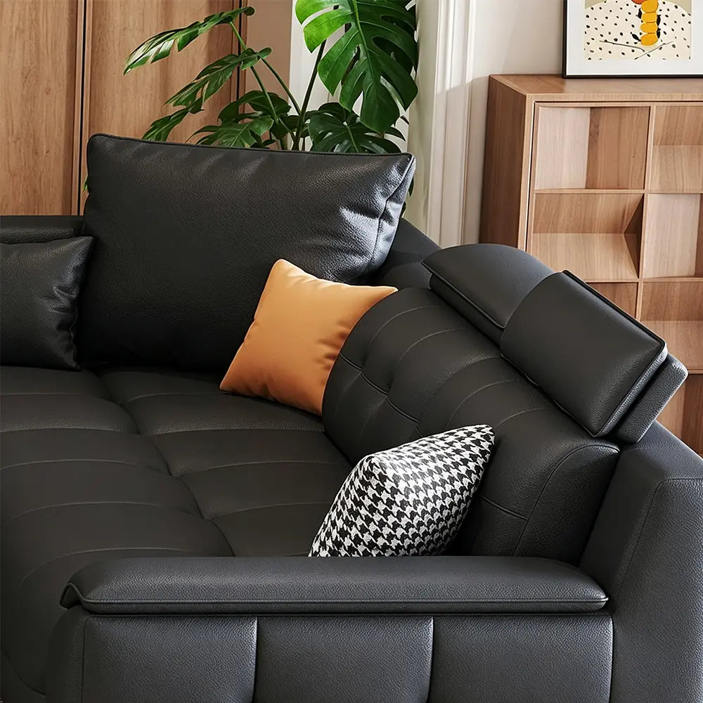 Angled detail of the black sofa's padded armrest, back cushions and chaise-side seating.