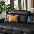 Detail of the black sofa's broad back cushion and headrest, styled with orange and patterned pillows.