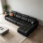Overhead angled view of the black sectional sofa's tufted seats and extended chaise section.