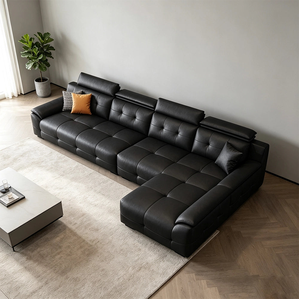Overhead angled view of the black sectional sofa's tufted seats and extended chaise section.