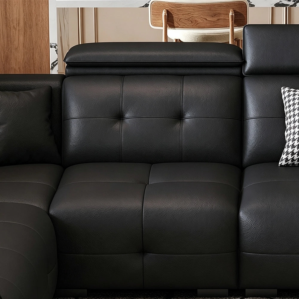 Close-up of a black sofa seat, tufted back cushion and padded headrest.