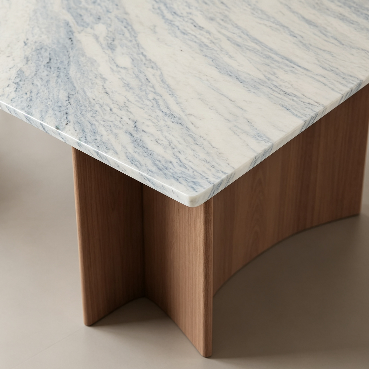 Detail of the dining table's rounded tabletop corner, blue-gray veining and wood-tone support below.