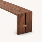 Close-up of the brown bench's seat seam, butterfly-shaped accent and broad right side support.