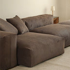 Close-up of the brown sofa's ribbed upholstery, deep seat modules and loose cushions.