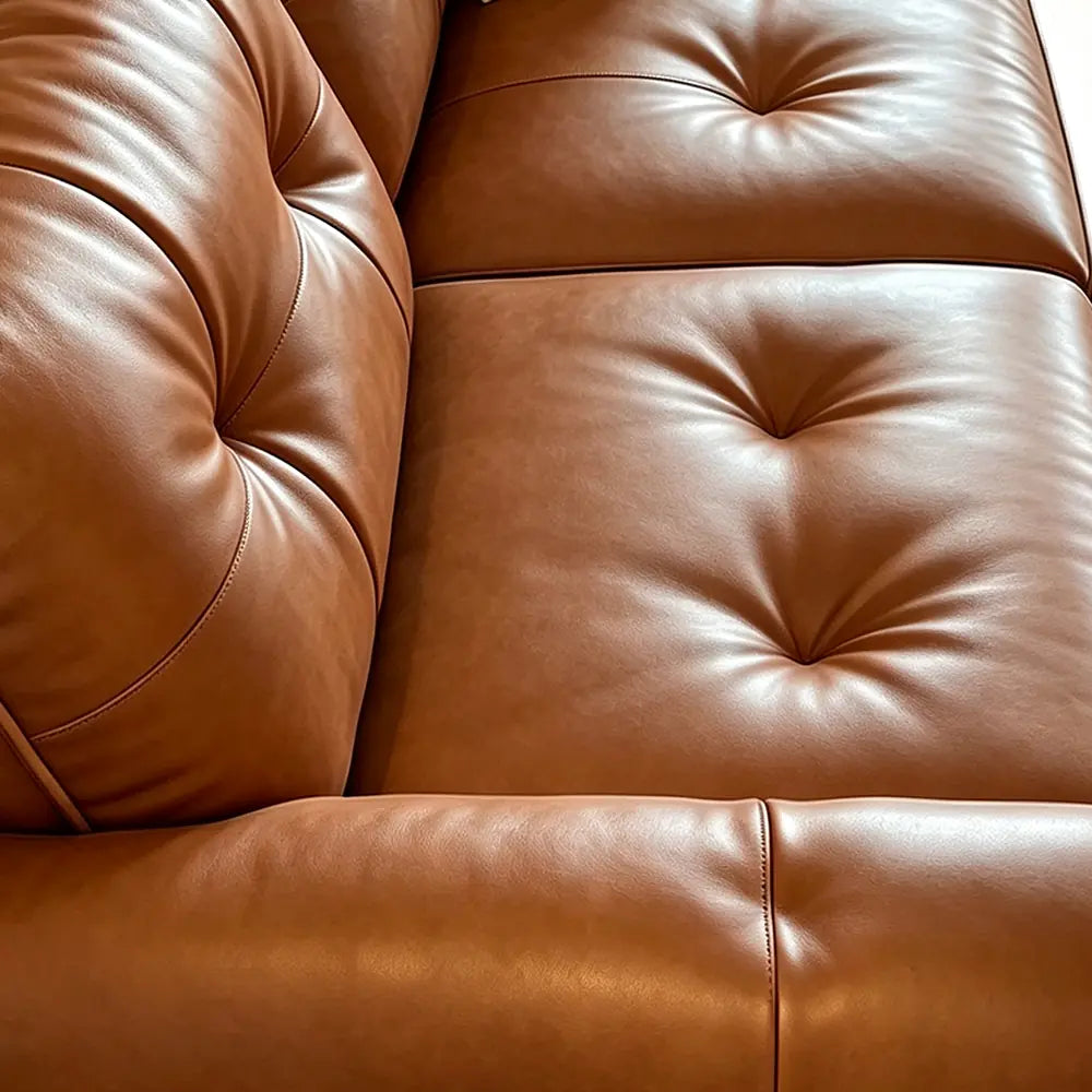 Close-up of the brown sofa bed's deeply tufted seat and back upholstery.