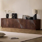 Angled view of the low brown TV cabinet with sculpted circular door patterns.