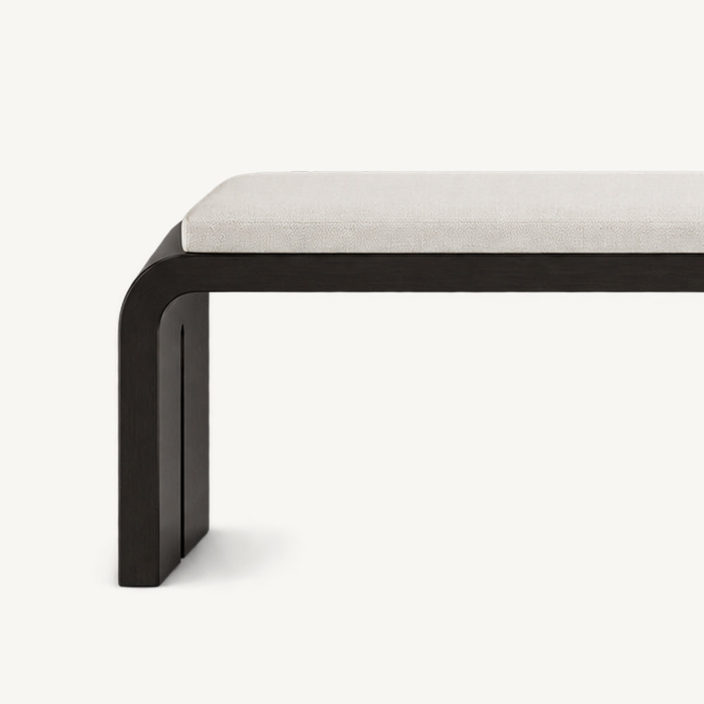 Close-up of the cream bench cushion above a rounded black frame corner and side support.
