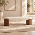 Cream cushioned bench with rounded brown end supports and a slim upholstered crossbar in a sunlit room.