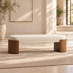 Cream cushioned bench with rounded brown end supports and a slim upholstered crossbar in a sunlit room.