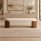 Front view of the cream upholstered bench with two broad rounded brown supports.