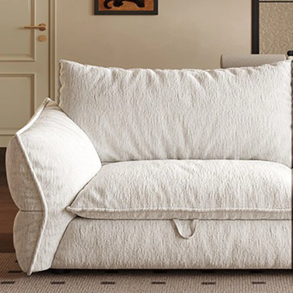 Front detail of the cream sofa bed's loose cushion, padded arm and fabric pull loop.