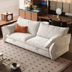 Cream sofa bed in the closed position with loose back cushions, padded arms and front pull loops.