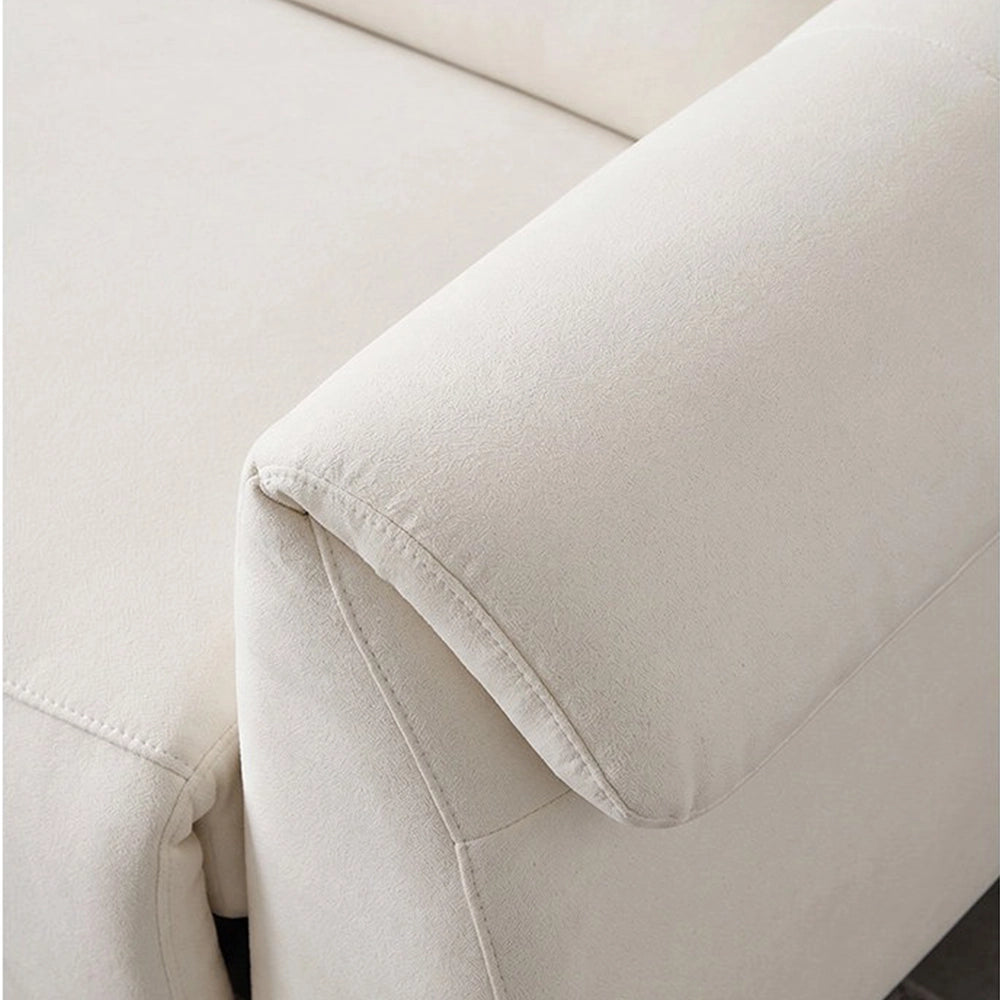 Close-up of the cream sofa's padded arm cushion and stitched upholstery edge.
