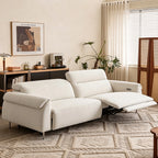 Angled view of the cream sofa with the right footrest extended as pictured and independently positioned backs.