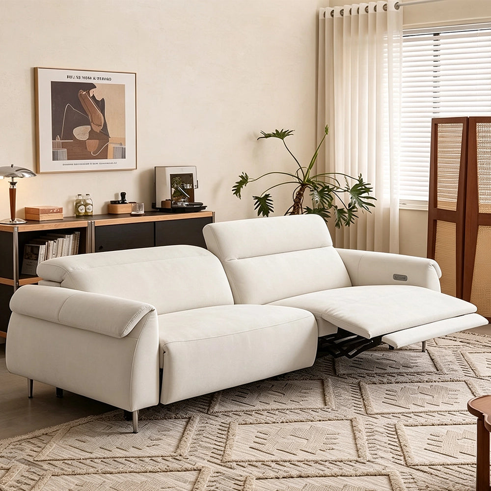 Angled view of the cream sofa with the right footrest extended as pictured and independently positioned backs.