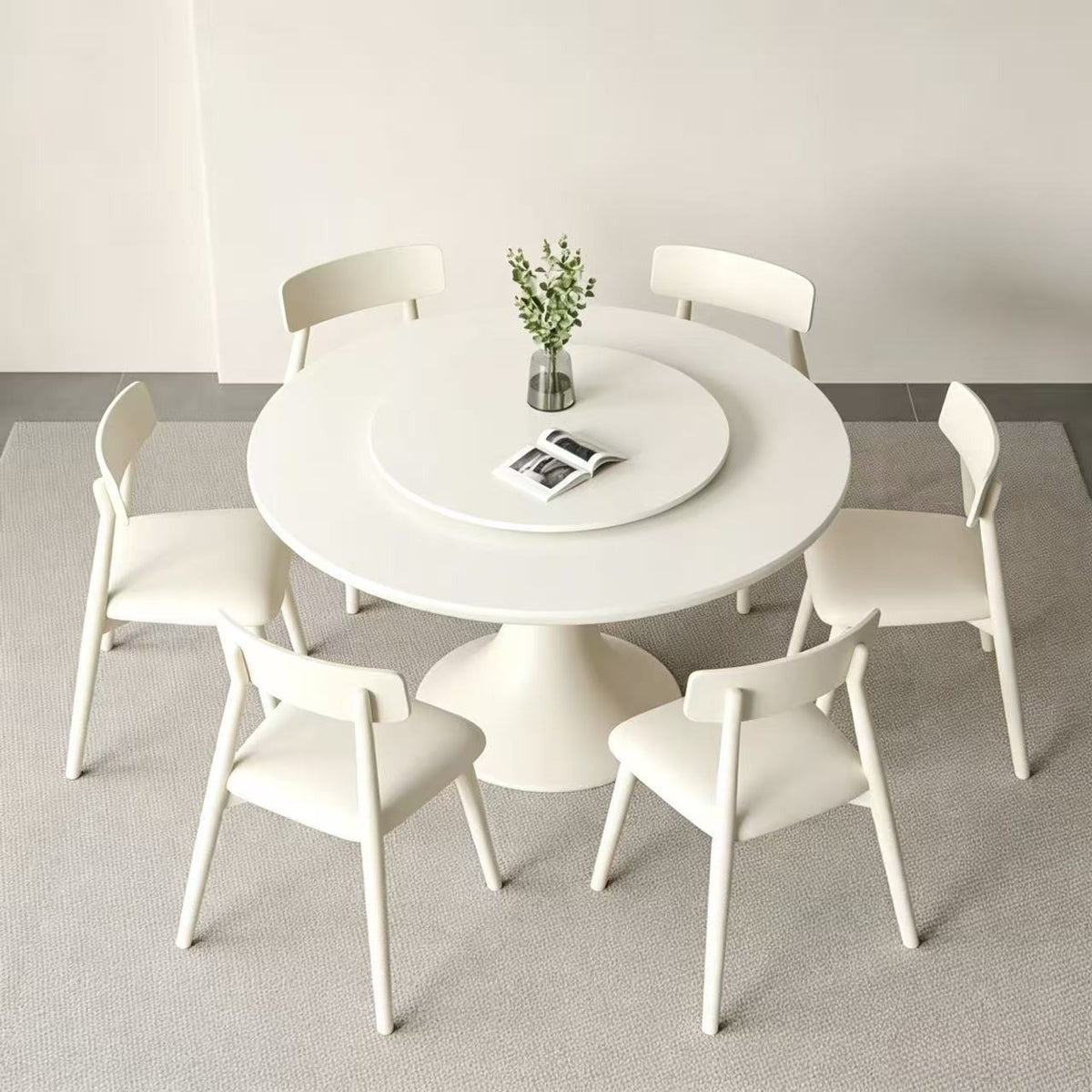 Cream round dining table with a matching central turntable, surrounded by pale chairs.