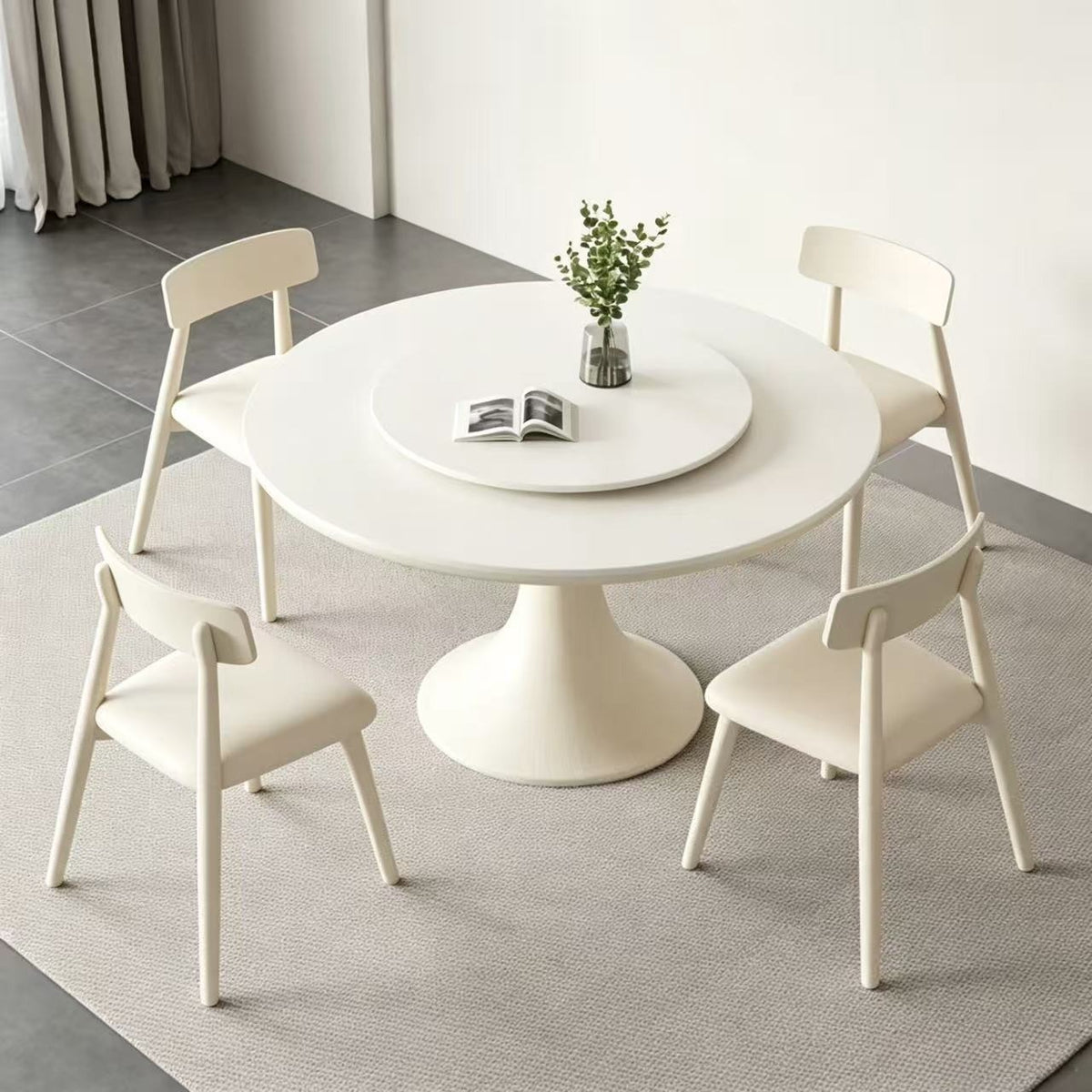 Angled overhead view of the cream round dining table, central turntable and matching chairs.