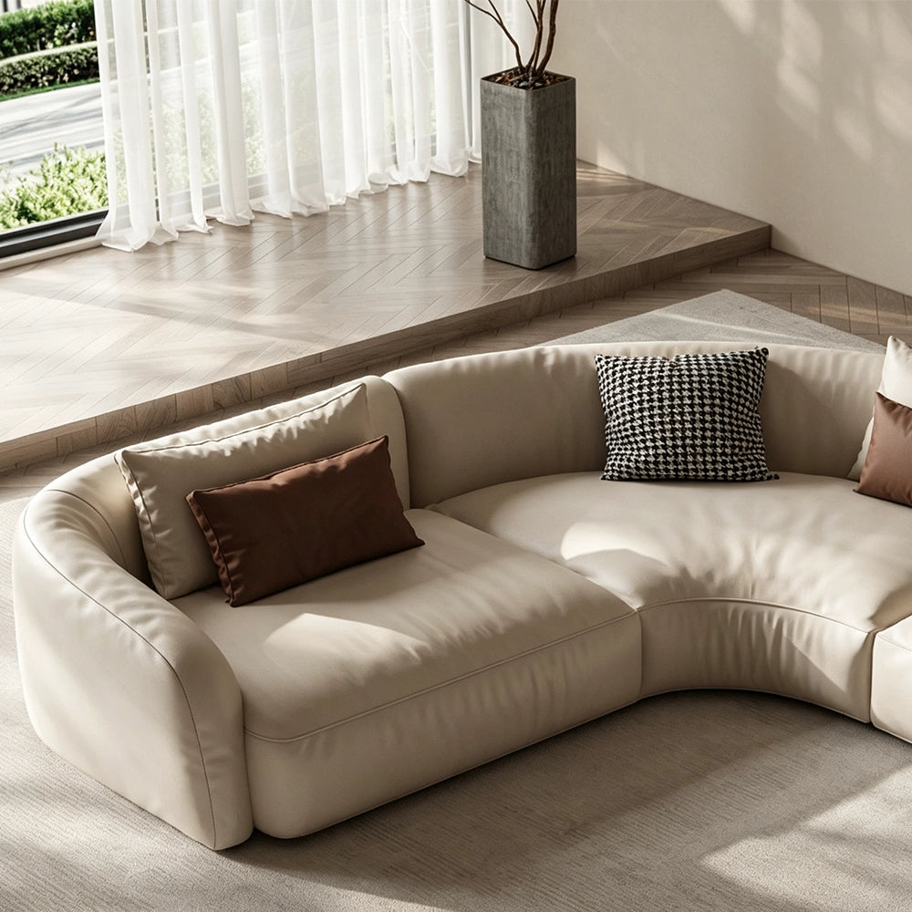 Detail of the cream modular sofa's curved corner seat and upholstered back.