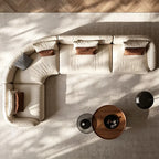Overhead view of a cream L-shaped modular sofa with rounded corners and loose accent cushions.