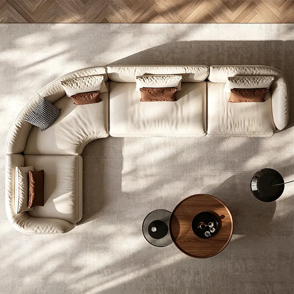 Overhead view of a cream L-shaped modular sofa with rounded corners and loose accent cushions.
