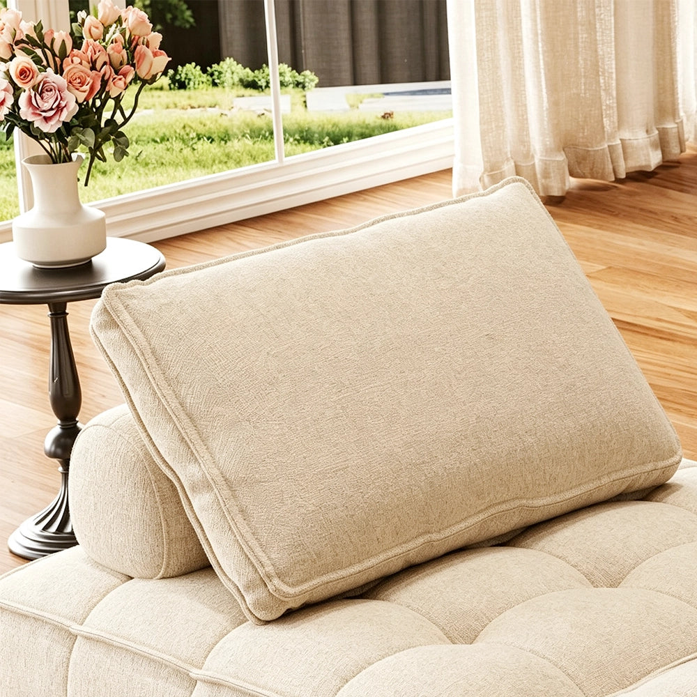 Close-up of a cream sofa back cushion with piped edging and a rounded bolster behind it.