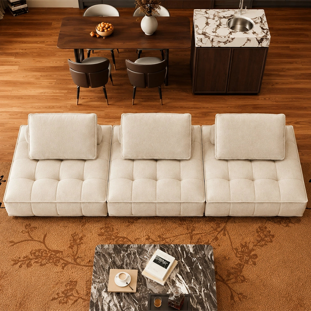 Overhead view of a cream three-section modular sofa with square-tufted seats and loose back cushions.