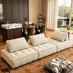 Wide angled view of the cream three-section modular sofa on a patterned rug.