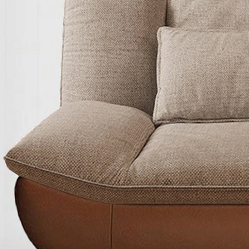 Close-up of the sofa's rounded taupe seat cushion and curved brown base.