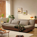 Sofa with taupe textured cushions, rounded arms and a smooth curved brown base in a living room.