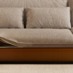 Detail of the sofa's broad seat cushions and two textured lumbar pillows.