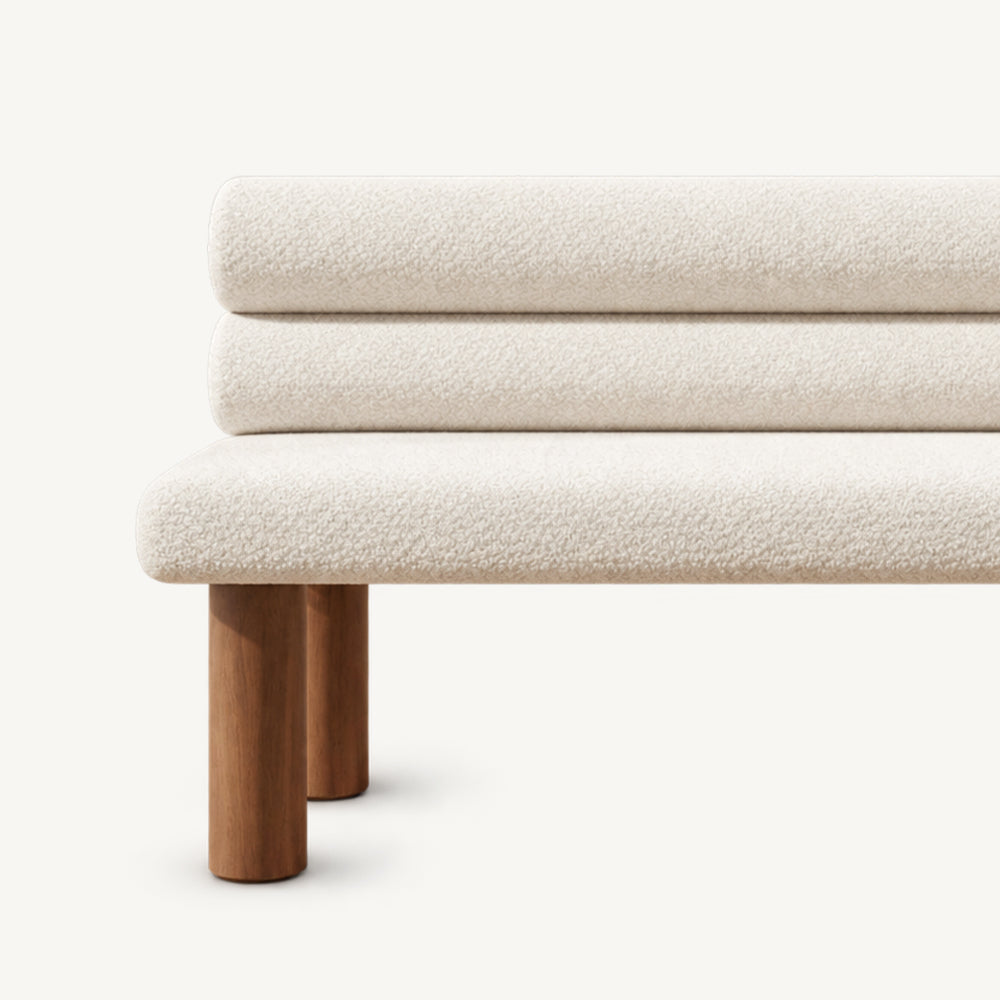 Front detail of the cream bench seat, stacked roll back cushions and brown legs.