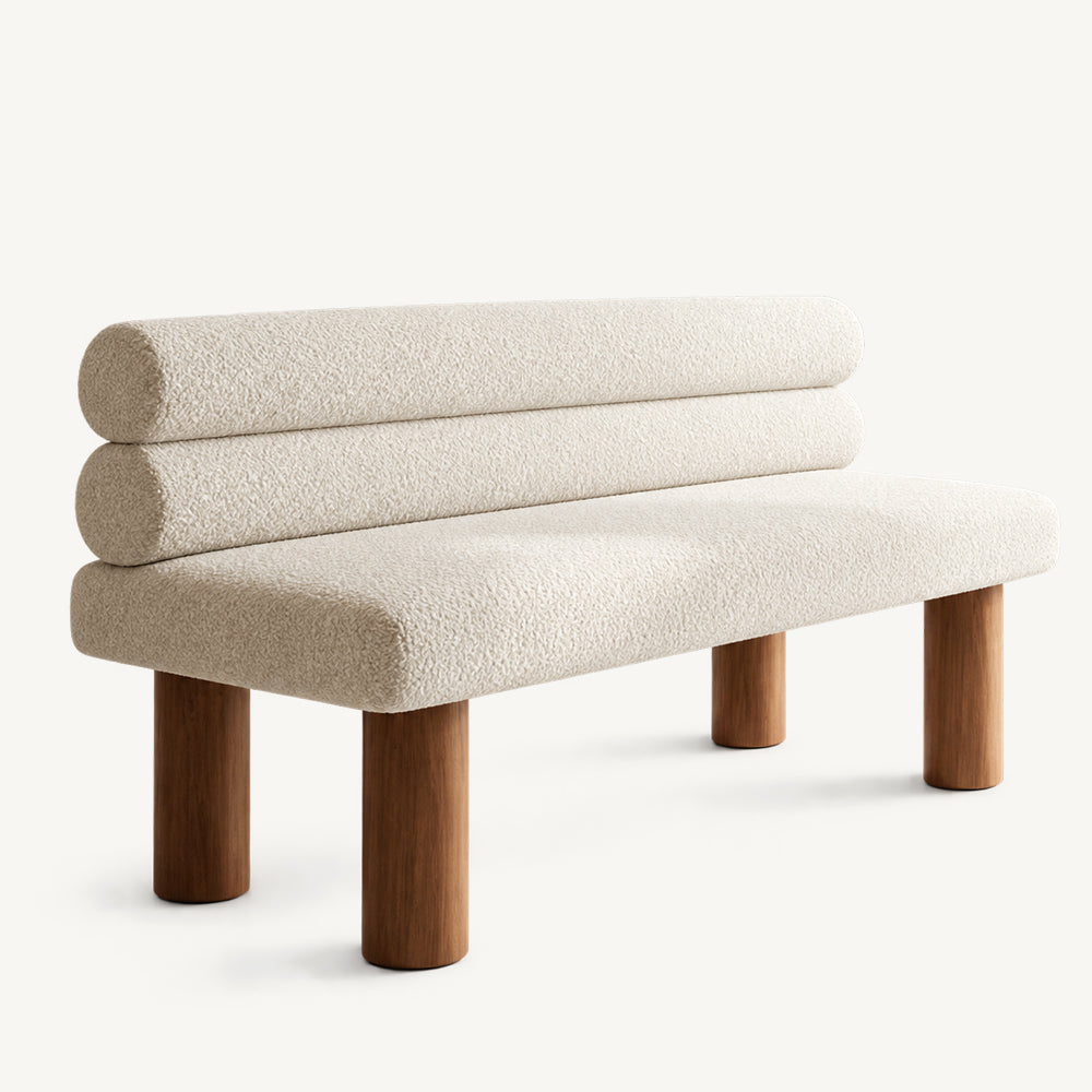 Cream upholstered bench with a rounded rectangular seat, two stacked cylindrical back cushions and brown legs.