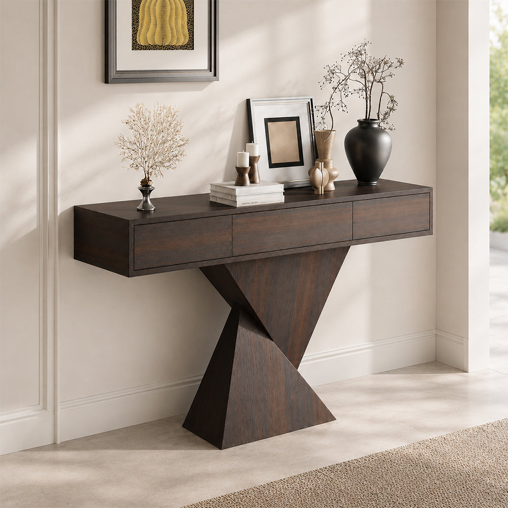 Angled entryway view of the dark console table, showing its drawer unit and crossed-panel pedestal.