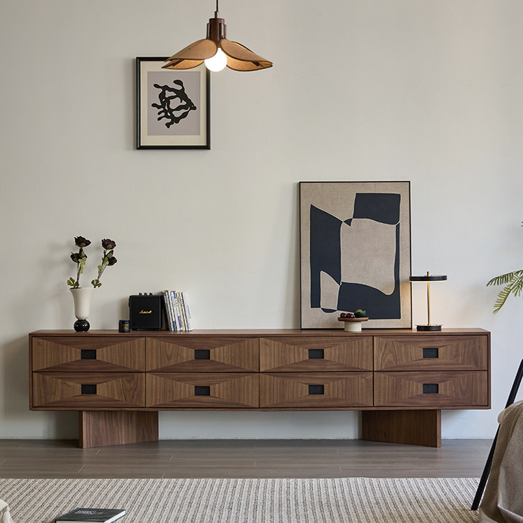 Brown TV stand with two rows of geometric drawer fronts and dark square pulls on broad panel legs.