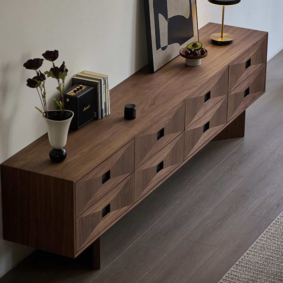 Angled overhead view of the wood-grain TV stand with sculpted drawer fronts and square recessed pulls.