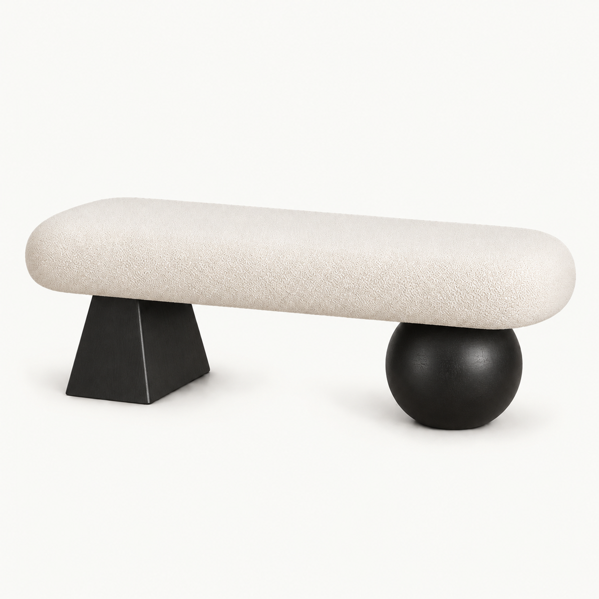 Cream rounded upholstered bench with a black tapered block leg and a black spherical leg.