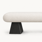 Close-up of the cream bench seat above its black tapered block support.