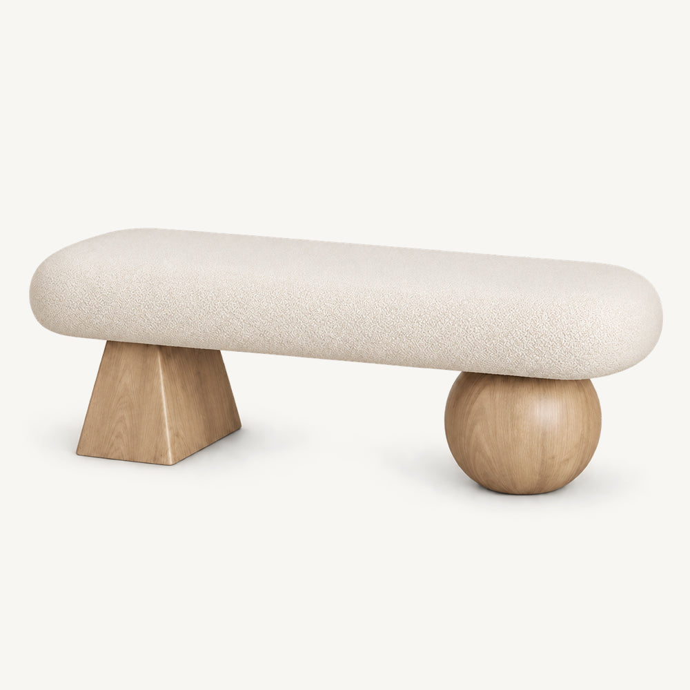 Cream rounded upholstered bench with a light wood-tone tapered block leg and a light wood-tone spherical leg.